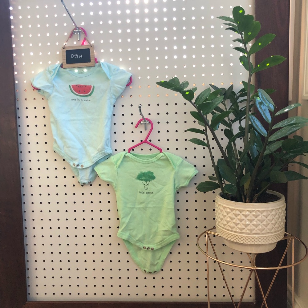 Two body suits with fruit and veggies on them